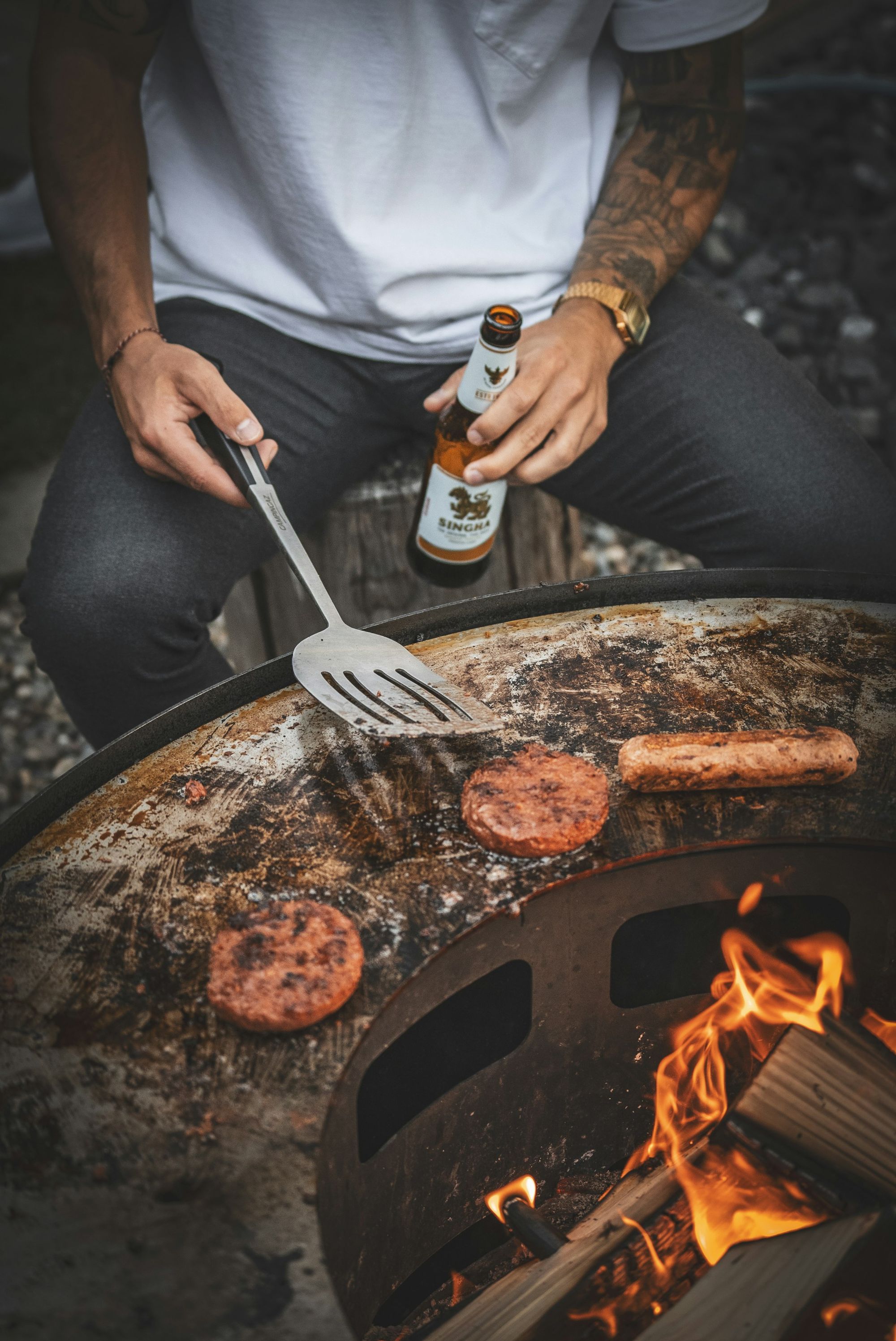 Churrasco na brasa com cerveja na mão